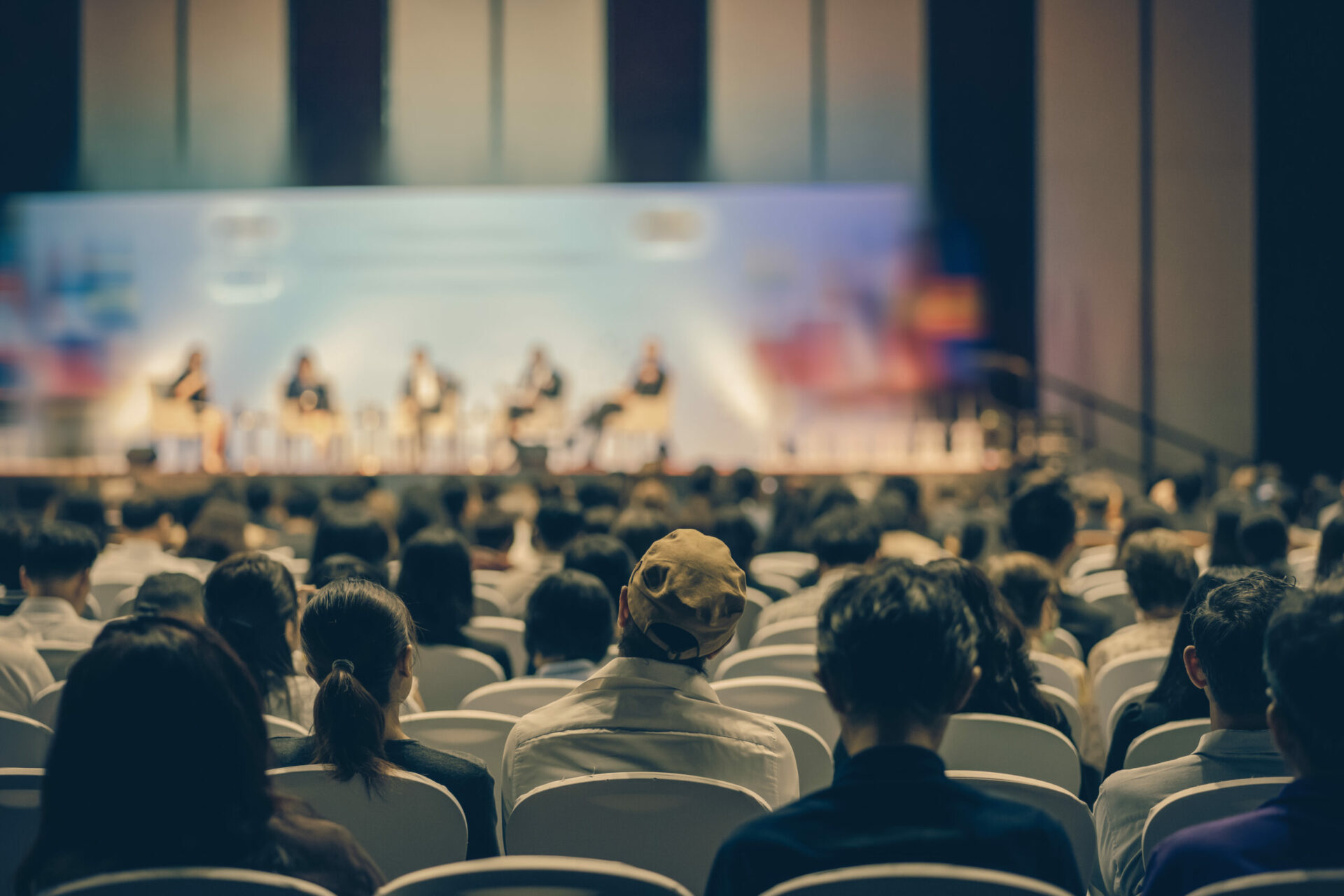 Rear view of Audience listening Speakers on the stage in the conference hall or seminar meeting, business and education about investment concept